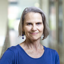 Smiling woman with short hair wearing a royal blue shirt.