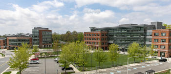 Five-story Merten Hall building with green lawn in front on Mason's Fairfax Campus.